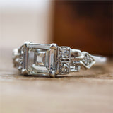 Art Deco Step Cut Diamond  Set In A Platinum Millgrain Ring With Six Single Cut Diamonds.