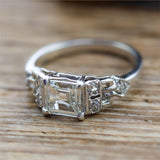 Art Deco Step Cut Diamond  Set In A Platinum Millgrain Ring With Six Single Cut Diamonds.