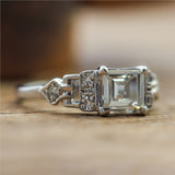 Art Deco Step Cut Diamond  Set In A Platinum Millgrain Ring With Six Single Cut Diamonds.