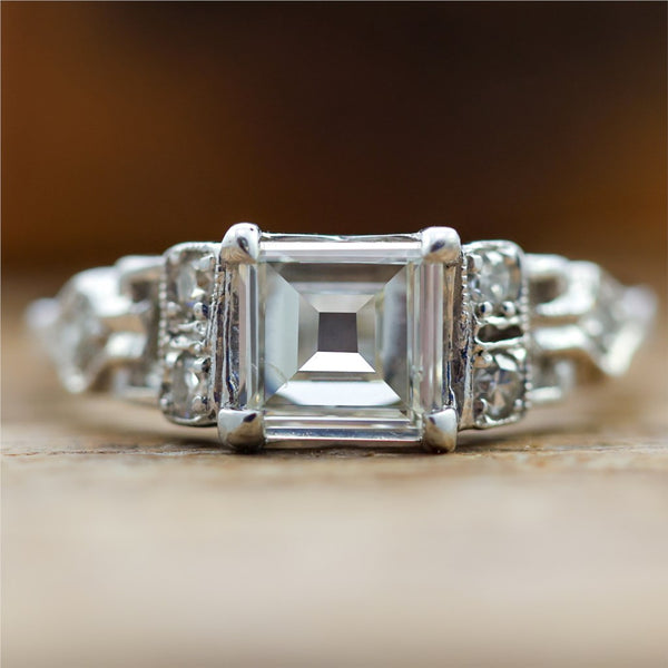 Art Deco Step Cut Diamond  Set In A Platinum Millgrain Ring With Six Single Cut Diamonds.