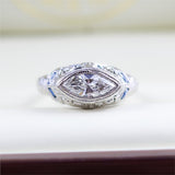 Art Deco 18kt white gold and sapphire mounting holding a modern .83 carat marquise shaped diamond