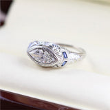 Art Deco 18kt white gold and sapphire mounting holding a modern .83 carat marquise shaped diamond