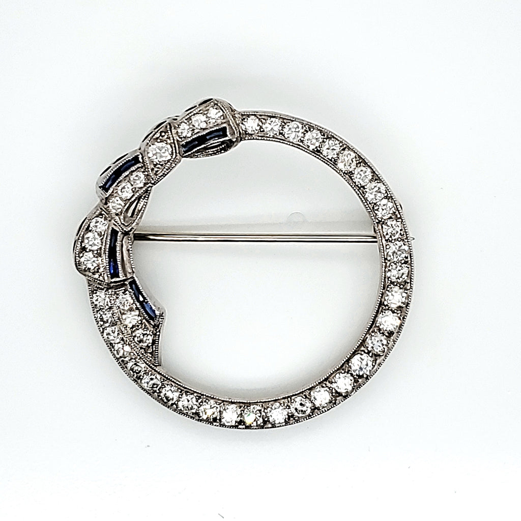 Art Deco platinum, diamond, and sapphire circle bow brooch