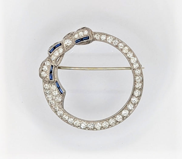 Art Deco platinum, diamond, and sapphire circle bow brooch