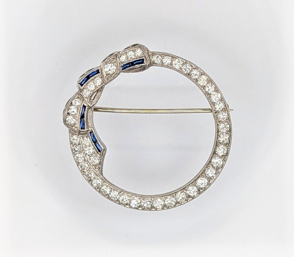 Art Deco platinum, diamond, and sapphire circle bow brooch
